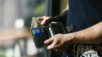 photograph of person holding black leather wallet with money Kenya faces economic strain with layoffs and cash flow issues; resilience, skill-building, cost optimization, and government support are key to recovery.